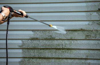 An,Unidentified,Man,Uses,A,Power,Washer,To,Clean,Mold